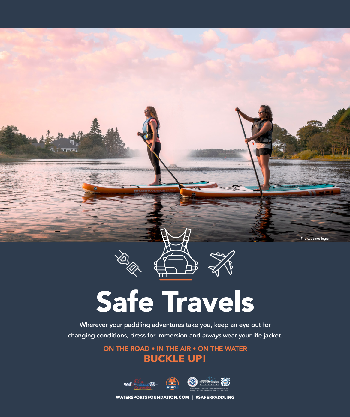 Royalty-free image - Two people stand on paddleboards on a calm lake under a pink sky. They wear life jackets. The scene is surrounded by a safety message: "Safe Travels. Buckle up!" promoting life jacket use during water activities.